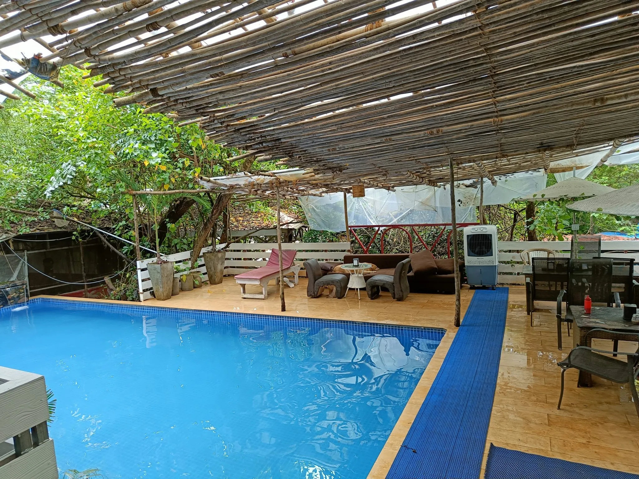 A poolside patio seating set beside a backyard swimming pool