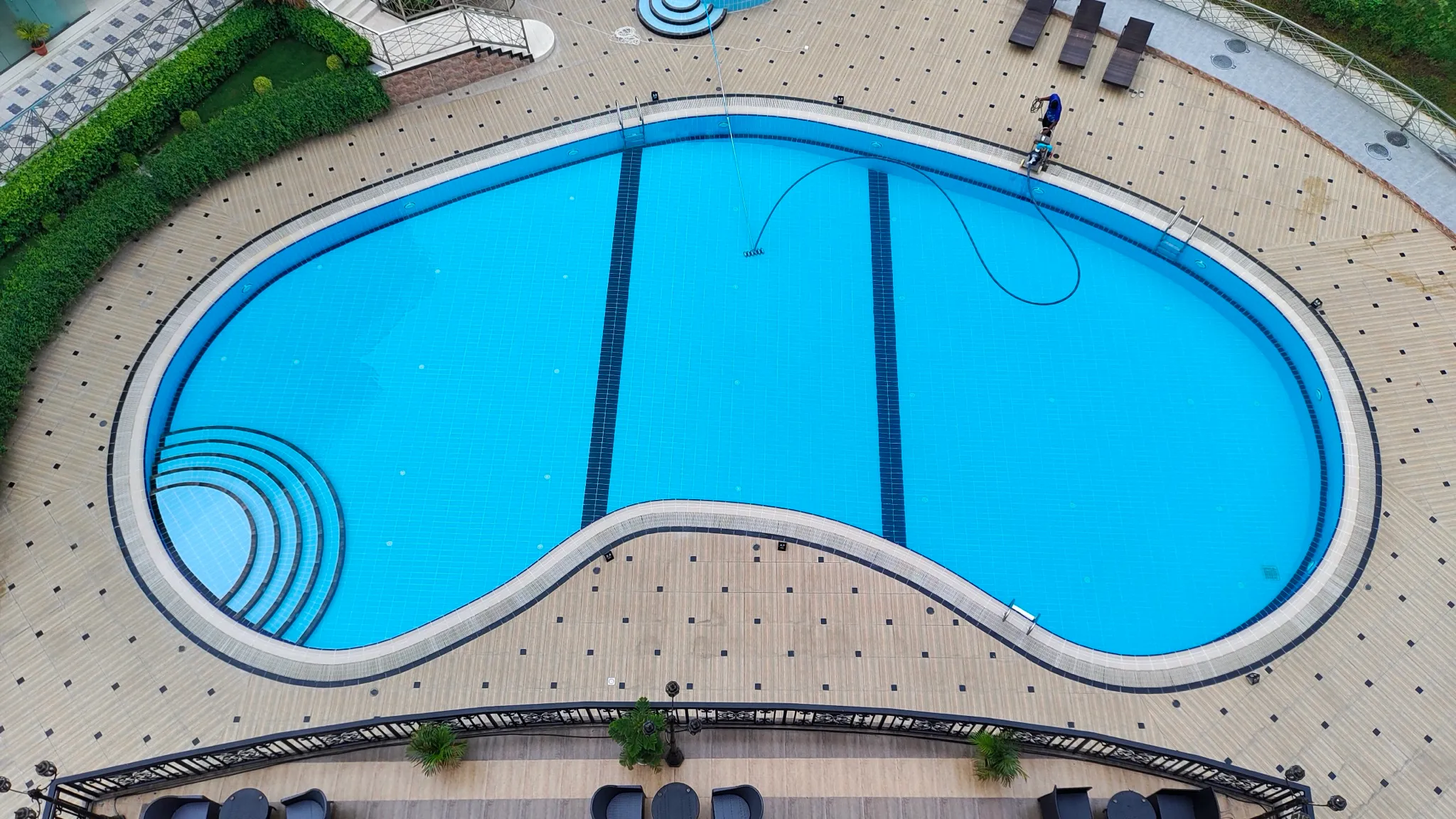 An above-ground pool seen from overhead, the shape of the water and the deck around it filling the frame
