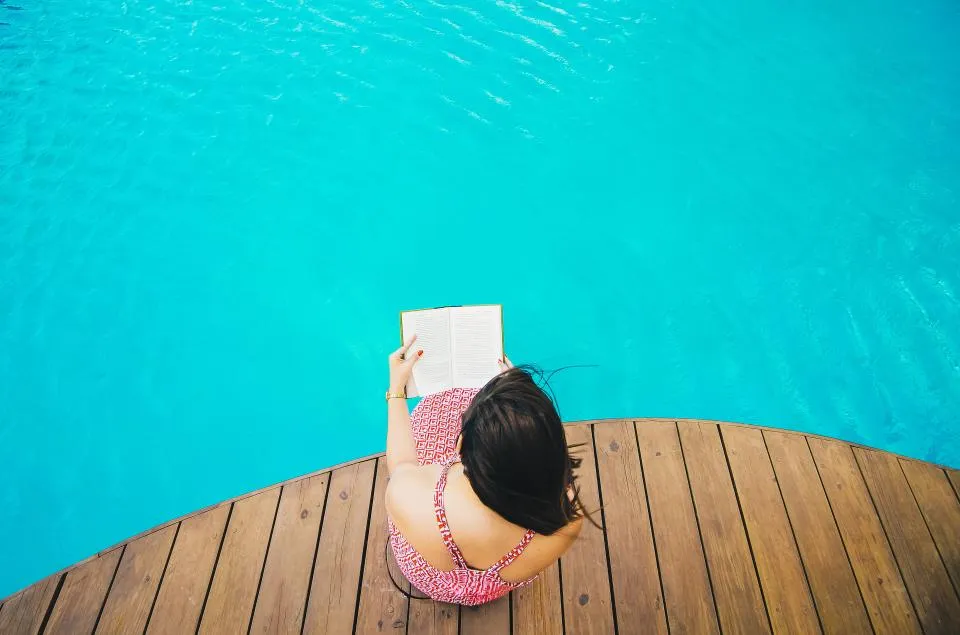 A tidy poolside deck with lounge seating beside a calm backyard swimming pool