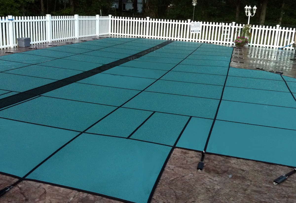 GLI HyPerLite solid safety cover installed over an in-ground pool, green
