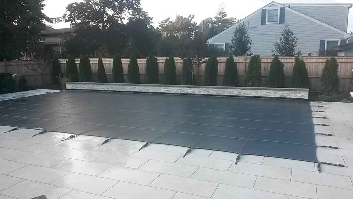 Loop-Loc Aqua-Xtreme safety cover installed over an in-ground pool, steel gray
